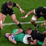 Ireland's number eight Caelan Doris (C) is tackled by New Zealand's openside flanker and captain Sam Cane (2R) during the France 2023 Rugby World Cup quarter-final match between Ireland and New Zealand at the Stade de France in Saint-Denis, on the outskirts of Paris, on October 14, 2023. (