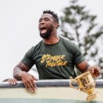 South Africa's flanker and captain Siya Kolisi reacts as he holds the throphy from the bus carrying the rest of the team during the Springboks Champions trophy tour in East London, South Africa, on November 5, 2023, after South Africa won the France 2023 Rugby World Cup final match against New Zealand.
